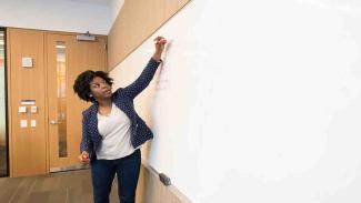 Unisa student teacher writes on dry erase board