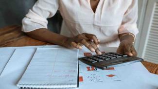 student calculates loan fees using calculator