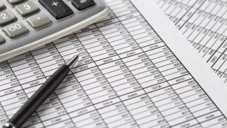 Financial records on a table with a pen and calculator
