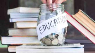 Student putting funding money in a jar labelled 'Education' that is surrounded by books