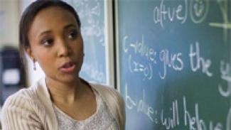 A teacher in front of a chalk board