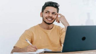 Male student sitting with laptop 