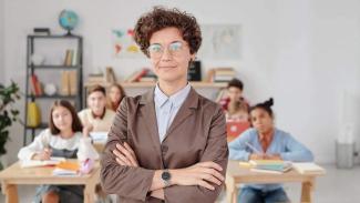 Woman in blazer standing in front of classroom