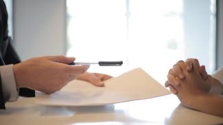 Person holding a pen and paper