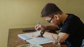 Student writing in a book
