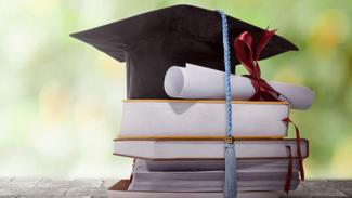 Graduation cap and certificate on textbooks